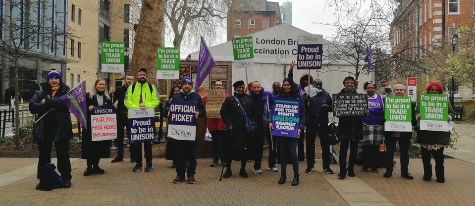 Members of UNISON on the picket line holding placards